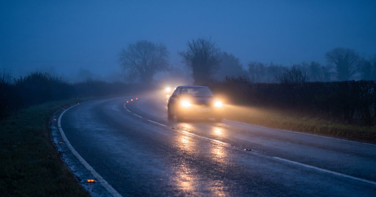 Night driving safety - UK road at dusk with car headlights